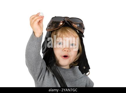 Portrait of a little sweet blonde girl in a pilot's helmet with glasses on her head isolated on white background Stock Photo