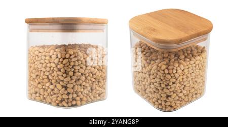 Cedar nuts in glass jar isolated on white background. Transparent glass package of pine nuts. Top view Stock Photo