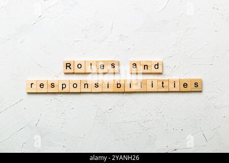roles and responsibilities word written on wood block. roles and responsibilities text on table, concept. Stock Photo