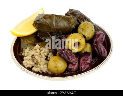 Stuffed vine leaves filled with rice and herbs and mixed Mediterranean olives on a small plate isolated on a white background Stock Photo