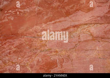 Rich red marble surface with golden veins, offering a luxurious texture for high-end decor. Stock Photo