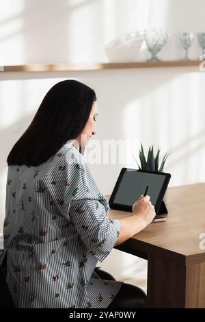 Woman Using Tablet for Digital Work at Modern Desk Stock Photo
