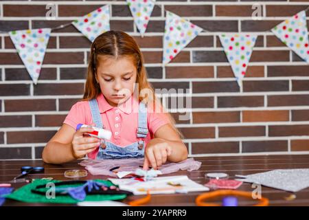 Cute preschooler girl makes art at a summer outdoor party. Stock Photo