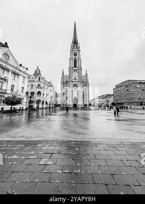 Rainy Day in Novi Sad: People at the Town Square and the Landmark- Name of Mary Church October 2024 Serbia Stock Photo