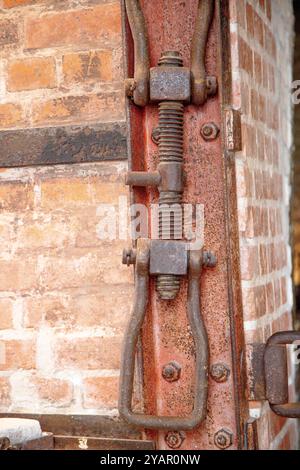 Close-up of a rusted screw and clamp mechanism, highlighting the aged metal's corrosion. Stock Photo