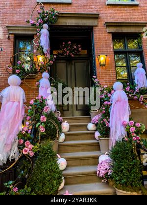Barbie themed Halloween decorations with pink ghosts and pumpkins on a townhouse in the West Village, New York City, NY, United States Stock Photo