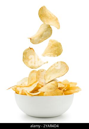 Potato chips falling into white bowl on white background. Stock Photo