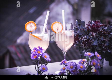 Trendy summer cold drink St Germain Spritz or Limoncello Spritz cocktail with lemon slices in beautiful sunset evening light Stock Photo