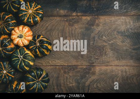 Various small pumpkins with a striped pattern on wooden background, top view with copy space Stock Photo