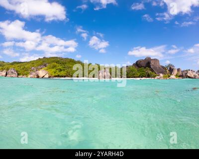 Tropical beach with turquoise water, white sand and palm trees seen from the sea Stock Photo