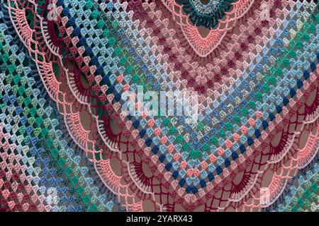 Handmade knitted shawl with a multi-colored pattern close-up Stock Photo