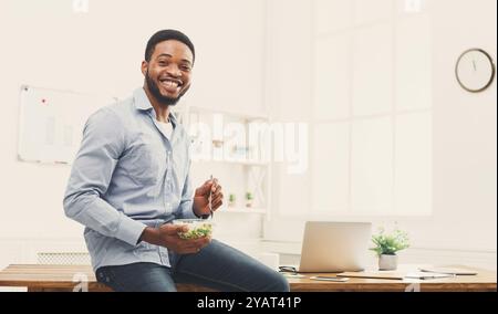 Young business woman eating salad at office Stock Photo