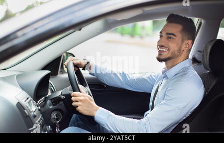 Excited arab guy going to office, driving his car Stock Photo