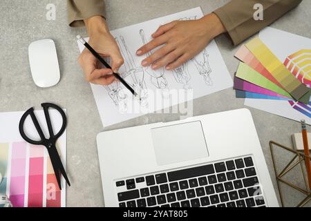 Fashion designer drawing sketch of stylish clothes at gray textured table, top view Stock Photo