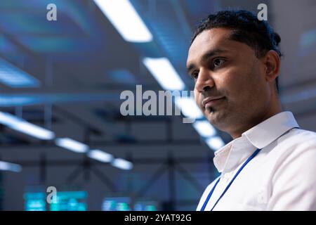 Engineer in data center walking through server racks used for computationally intensive tasks such as quantum mechanics or weather forecasting. Expert running routine equipment diagnosis, close up Stock Photo