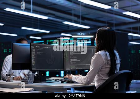 Software developers in data center running system diagnostic tests on PC to fix problems. IT staff members deploying and error checking utilities on computers to repair network issues performance Stock Photo