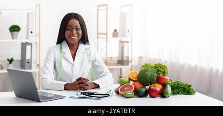 Smiling doctor nutritionist with vegetable and fruit in office Stock Photo
