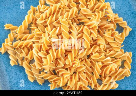 Close-up of raw pasta on a blue plate. Stock Photo