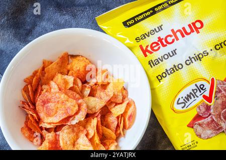 A small bowl of ketchup flavored potato chips, a popular snack in Canada Stock Photo
