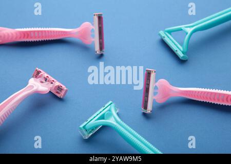 Many women razors on the blue background. Top view Stock Photo