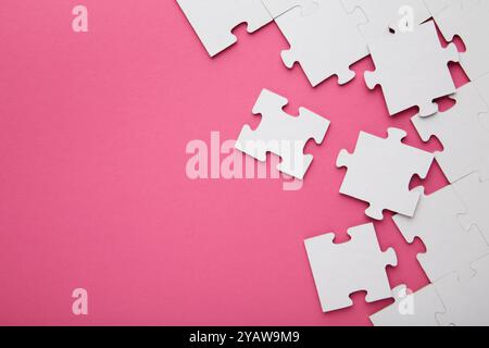 Close-up of a pile of uncompleted elements of a white puzzle. A huge number of rectangular pieces from one large white mosaic. Top view Stock Photo