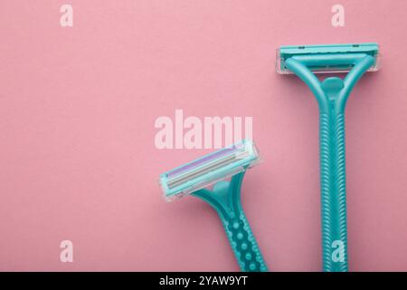 Blue razors for hair removal on pink background. Top view Stock Photo