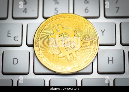 Bitcoin coin on computer keys on white background Stock Photo