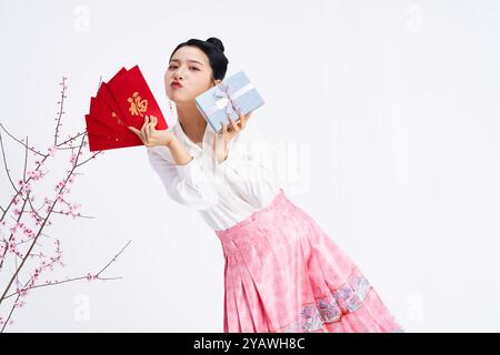 A young Chinese woman holding red envelopes and gift boxes Stock Photo