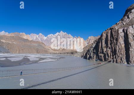 Landscape view of Hussaini suspension bridge above Hunza river with Tupopdan peak in background, Hussaini, Gojal, Hunza, Gilgit-Baltistan, Pakistan Stock Photo