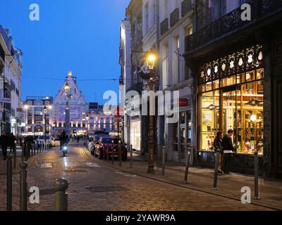 France. Lille, The Grand Place by night, seen from the rue Esquermoise. The old town of Lille is the usual meeting place for young students to party.  FRANCE, LILLE, LILLOIS, LILLOISE, REAL ESTATE, BUILDING, HOUSE, HOUSING, DWELLING, WINDOW, DOOR, ROOF, BRICK, CHIMNEY, STREET, CITY, ANCIENT, TRADITIONAL, HERITAGE, OLD LILLE, TOURIST AREA, TOURISTS, WALKERS, PROMENADE, DOWNTOWN, OFFICIAL BUILDING, CHAMBER OF COMMERCE, BELFRY, NIGHT, NOCTURNAL, DARK, YOUTH, YOUNG, STUDENTS, PARTY, DATE, FASHIONABLE AREA, BARS, CAFES, COFFEE SHOP, RESTAURANT, DRINK, BEVERAGES Stock Photo
