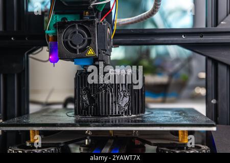 A 3D printer prints a black model. Technology at home Stock Photo