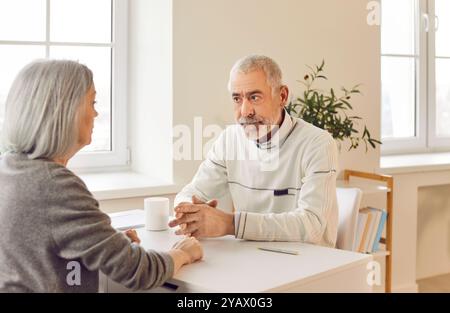 Senior Couple Having A Serious Conversation At Home Stock Photo
