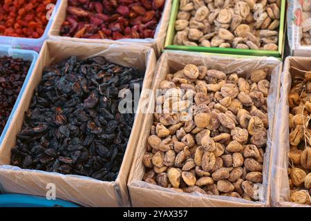 Colorful trays filled with a variety of dried fruits and nuts are displayed at a bustling market in Turkey. Vendors showcase their fresh and natural p Stock Photo