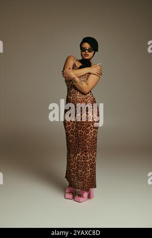 The stylish young woman confidently poses with her arms crossed, embracing her fashion forward look. Stock Photo