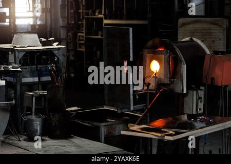 Industrial glassblowing furnaces actively running in glassware factory ...