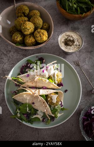 A delicious falafel wrap filled with fresh vegetables and topped with a tasty sauce, perfect for a healthy meal Stock Photo