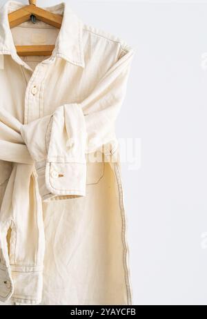 Casual shirt displayed on wooden hanger close up. Stock Photo
