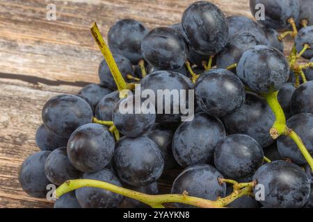 bunch of black grapes, close-up, on a wooden table Stock Photo