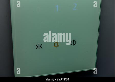 A sleek elevator control panel features illuminated numbers and icons, showcasing advanced technology and minimalist aesthetics in an urban building. Stock Photo