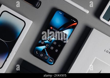 LONDON - OCTOBER 15, 2024: Apple iPhone Pro top view on desk with office tech accessories Stock Photo