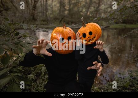 Scary child boy with his father dad with pumpkins heads, Halloween. Jack-o-lantern costumes.Trick or treat, family scares you, playing in horror Stock Photo