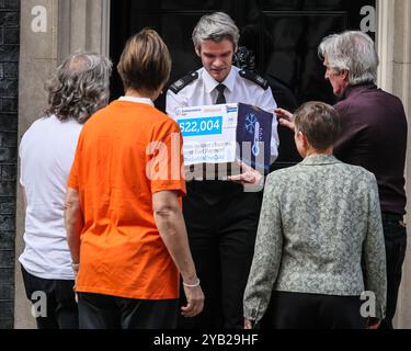 London, UK. 16th Oct, 2024. Robert Trewhella, 68, from Cornwall hands in the box with signatures to Downing Street staff. Charities Independent Age, 38 Degrees, Silver Voices, Organise and others this afternoon hand in a petition to 10 Downing Street with more than 500,000 signatures, calling on the UK Government to protect the Winter Fuel Payment Credit: Imageplotter/Alamy Live News Stock Photo