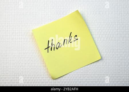 Thank You written on yellow paper note on white textured background top view Stock Photo