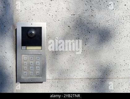 Metal intercom with keypad on concrete wall Stock Photo