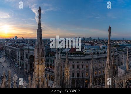 A picture of the Duomo di Milano or Milan Cathedral roof spires and statues overlooking the Porta Nuova business district, at sunset. Stock Photo