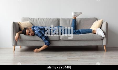 Exhausted Sleepless Young Man Lying On The Couch Stock Photo