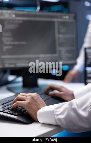 Admin in data center checking equipment performance on computer after upgrading infrastructure. Close up shot of IT employee doing maintenance on storage arrays in servers room Stock Photo