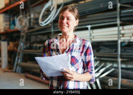 Joyful woman inspecting warehouse Stock Photo
