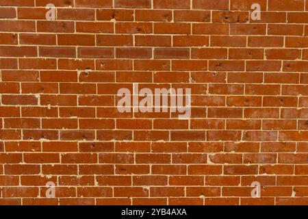 Red brick background that has grey paint pattern full copy space. Red brick background that has damage and holes newer construction white filler paint Stock Photo