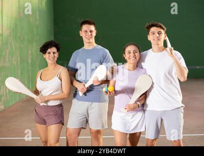 Two happy couples after playing paleta fronton on tennis court Stock Photo